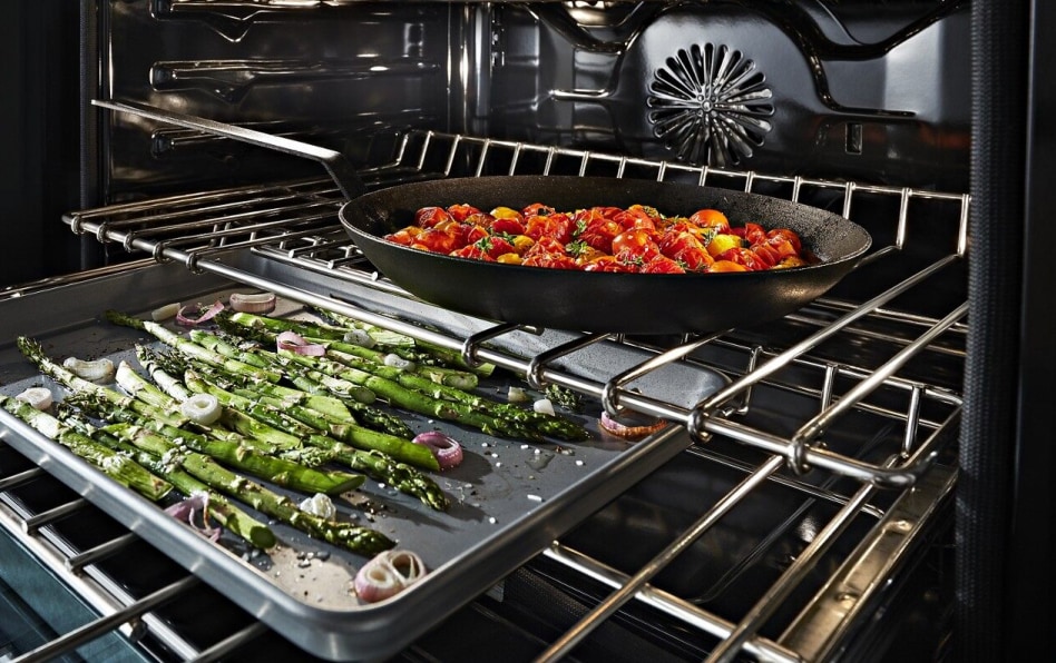 Convection oven open with several dishes cooking Convection oven open with several dishes cooking