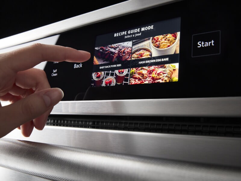 A person selecting an Assisted Cooking Mode on a KitchenAid® smart oven