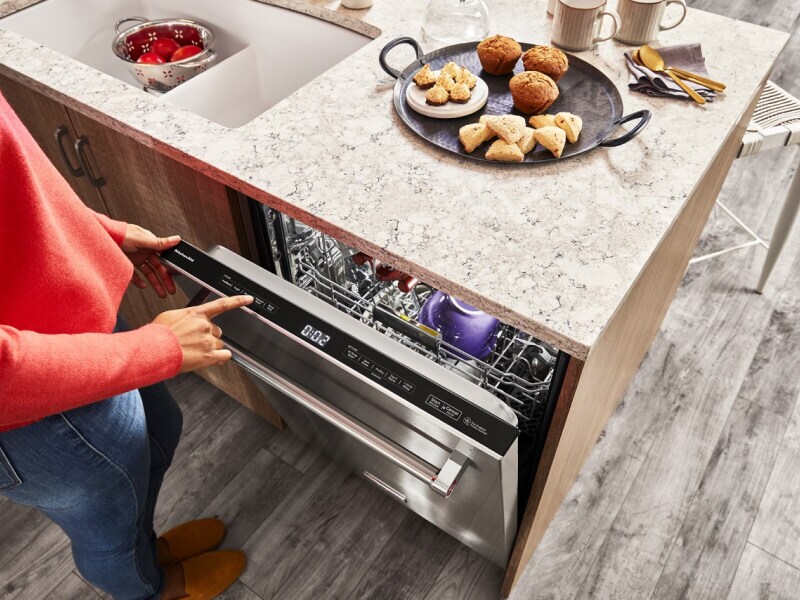 Person selecting settings on a KitchenAid® dishwasher