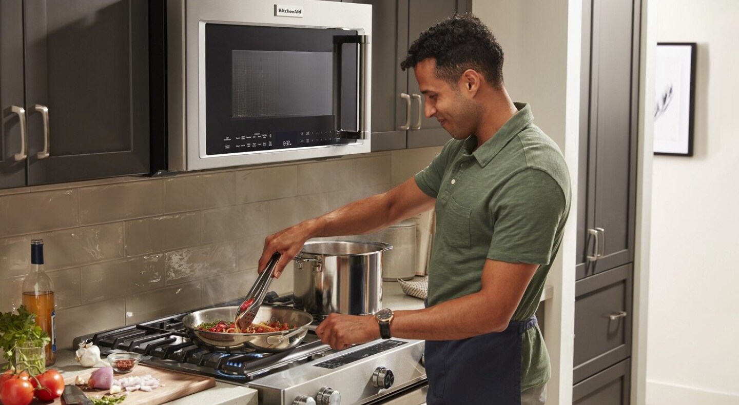 Person cooking pasta on a range