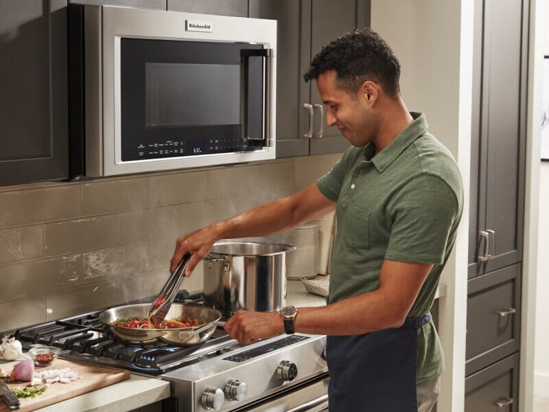 Person cooking pasta on a range