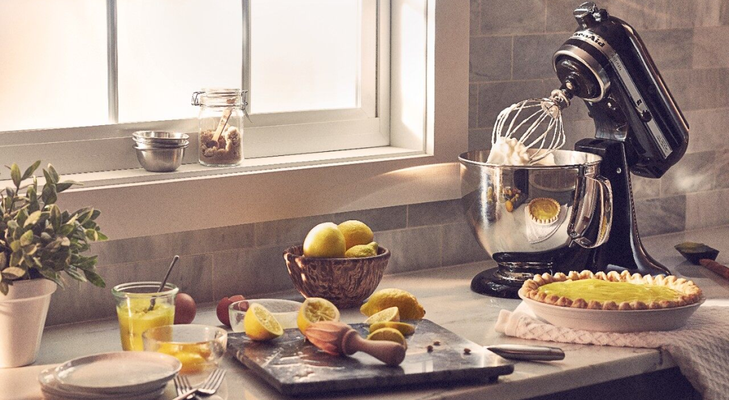 A black KitchenAid® stand mixer next to a lemon pie and lemon slices. A black KitchenAid® stand mixer next to a lemon pie and lemon slices.