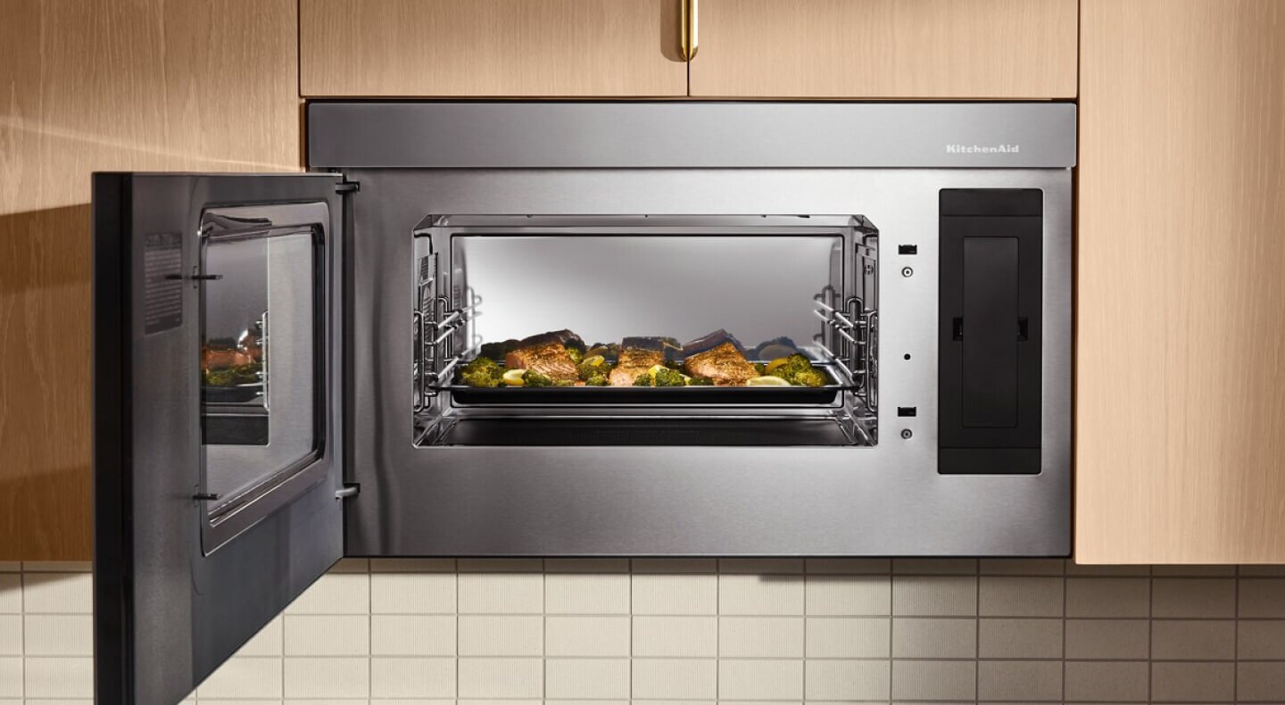 An open KitchenAid® microwave with a dish inside An open KitchenAid® microwave with a dish inside