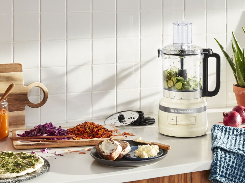 KitchenAid® food processor with grated zucchini and homemade pizza ingredients KitchenAid® food processor with grated zucchini and homemade pizza ingredients