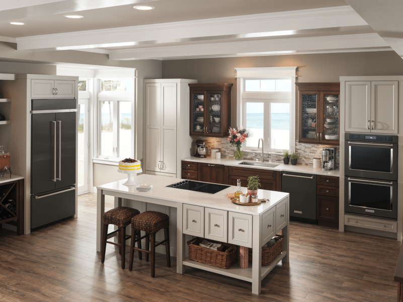 Full kitchen view with black french door refrigerator adjacent to island cooktop Full kitchen view with black french door refrigerator adjacent to island cooktop