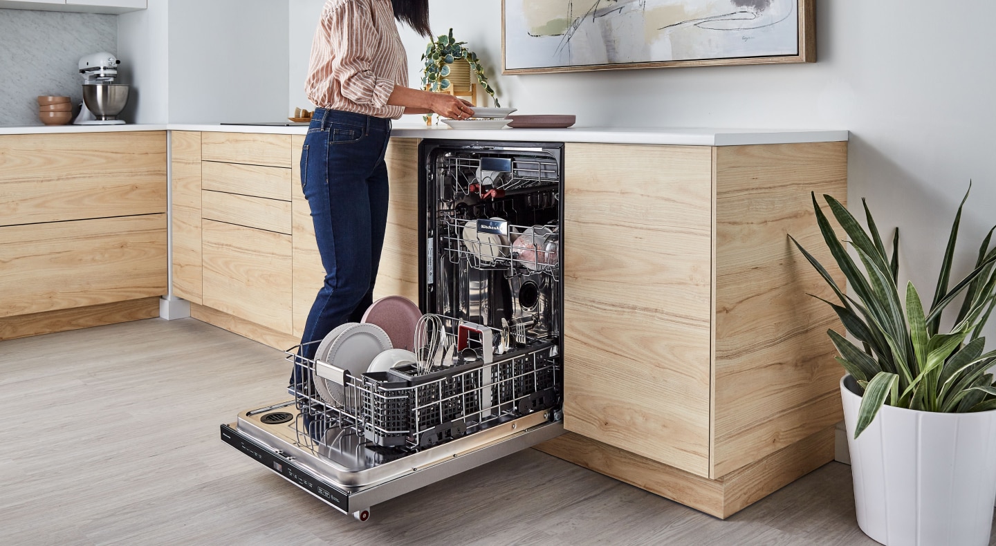 Person unloading dishwasher Person unloading dishwasher
