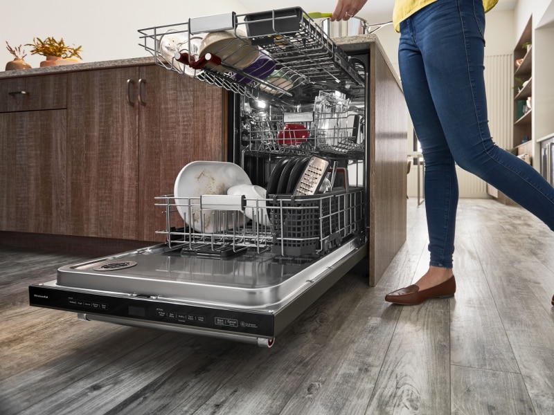 Person unloading dishwasher Person unloading dishwasher