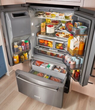 Open French door refrigerator filled with groceries