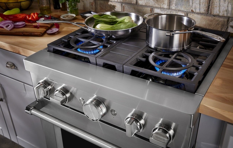 KitchenAid gas oven with open flames and pots on the back burners