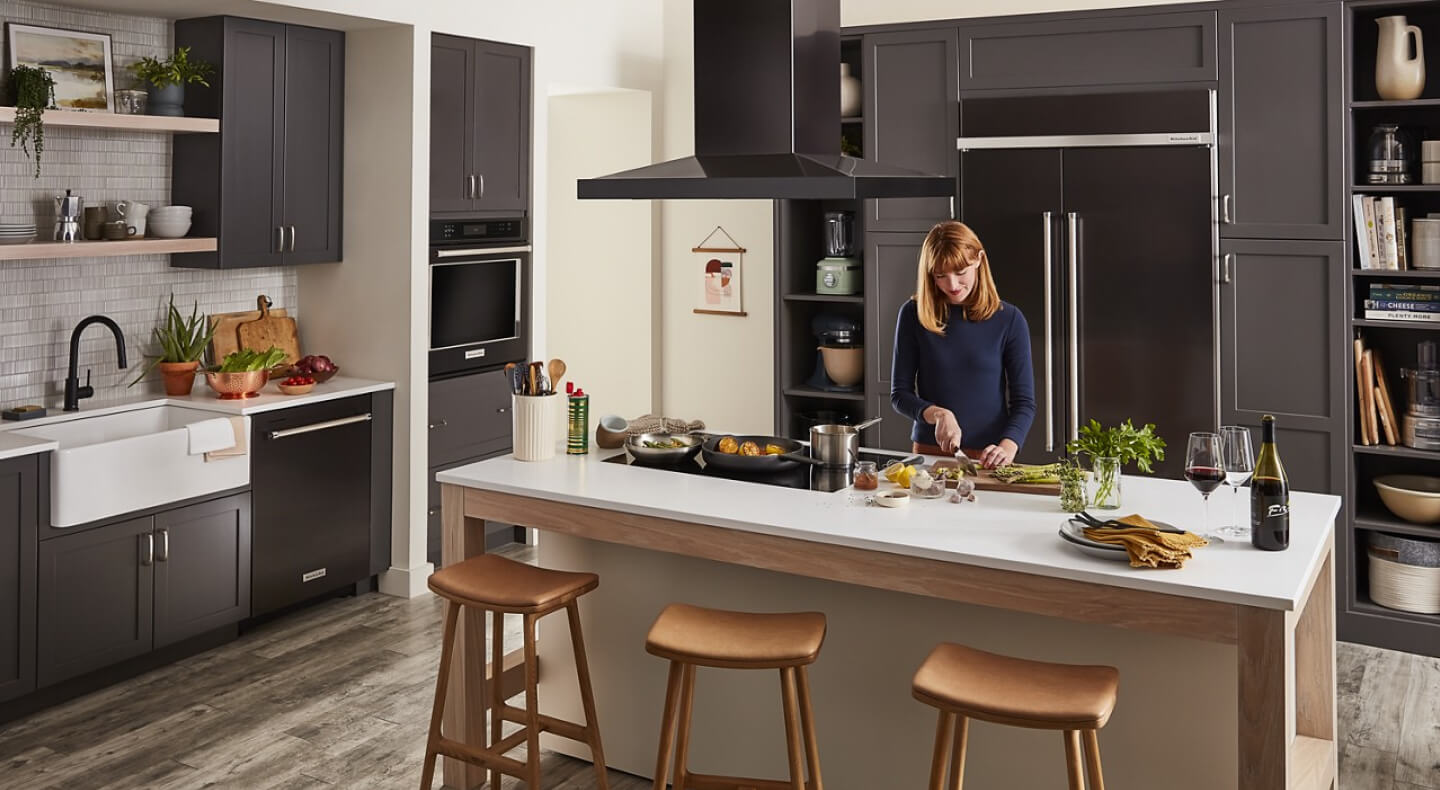 Person chopping vegetables on a kitchen island