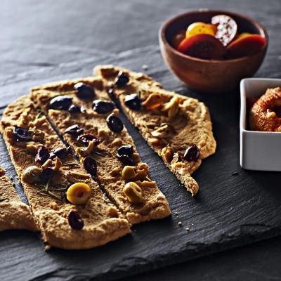 Sliced socca topped with olives