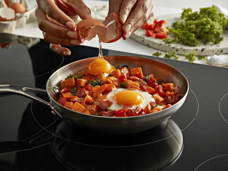 A person cracking an egg into a dish A person cracking an egg into a dish