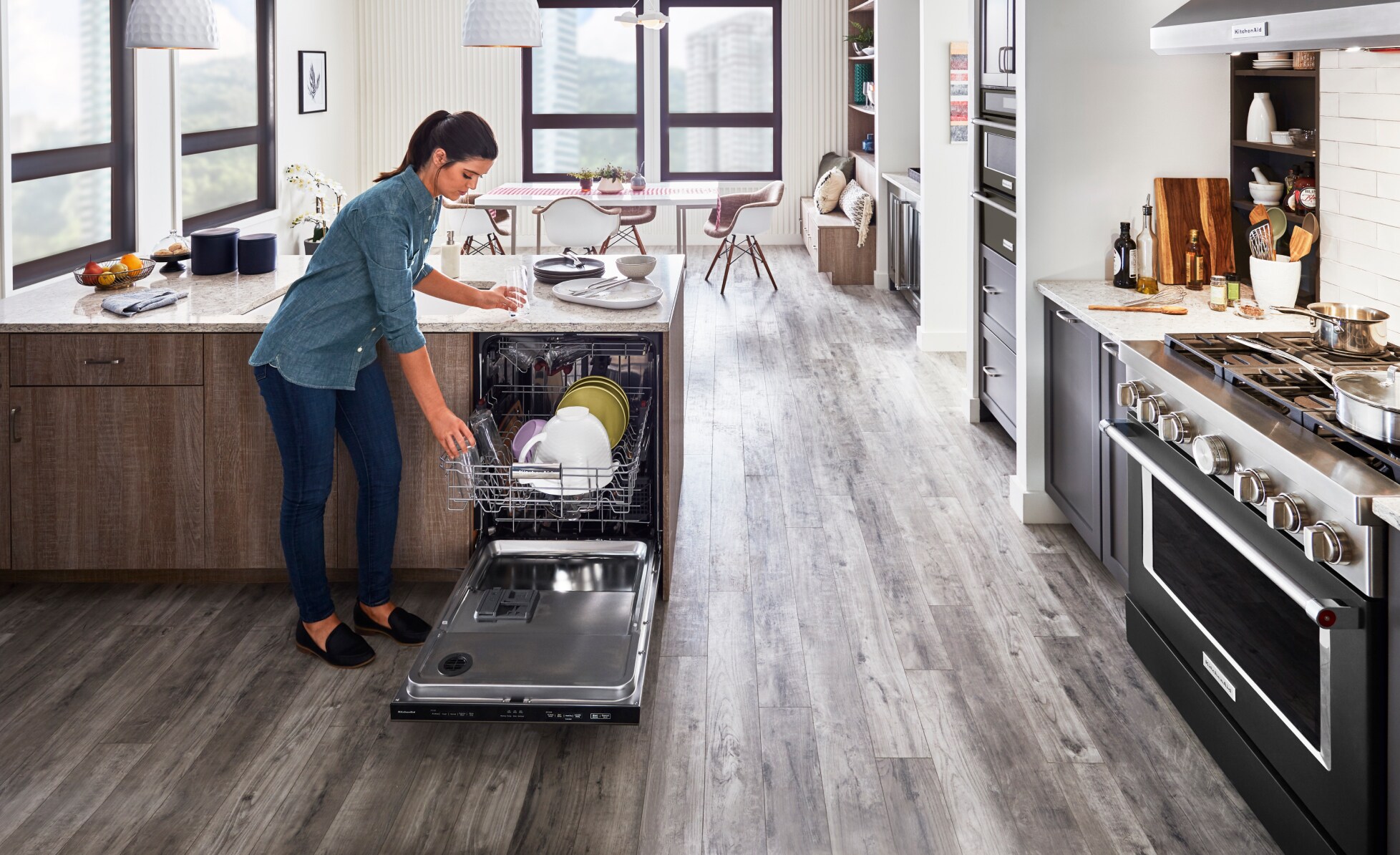 Person putting dishers in a KitcheAid® diswasher.
