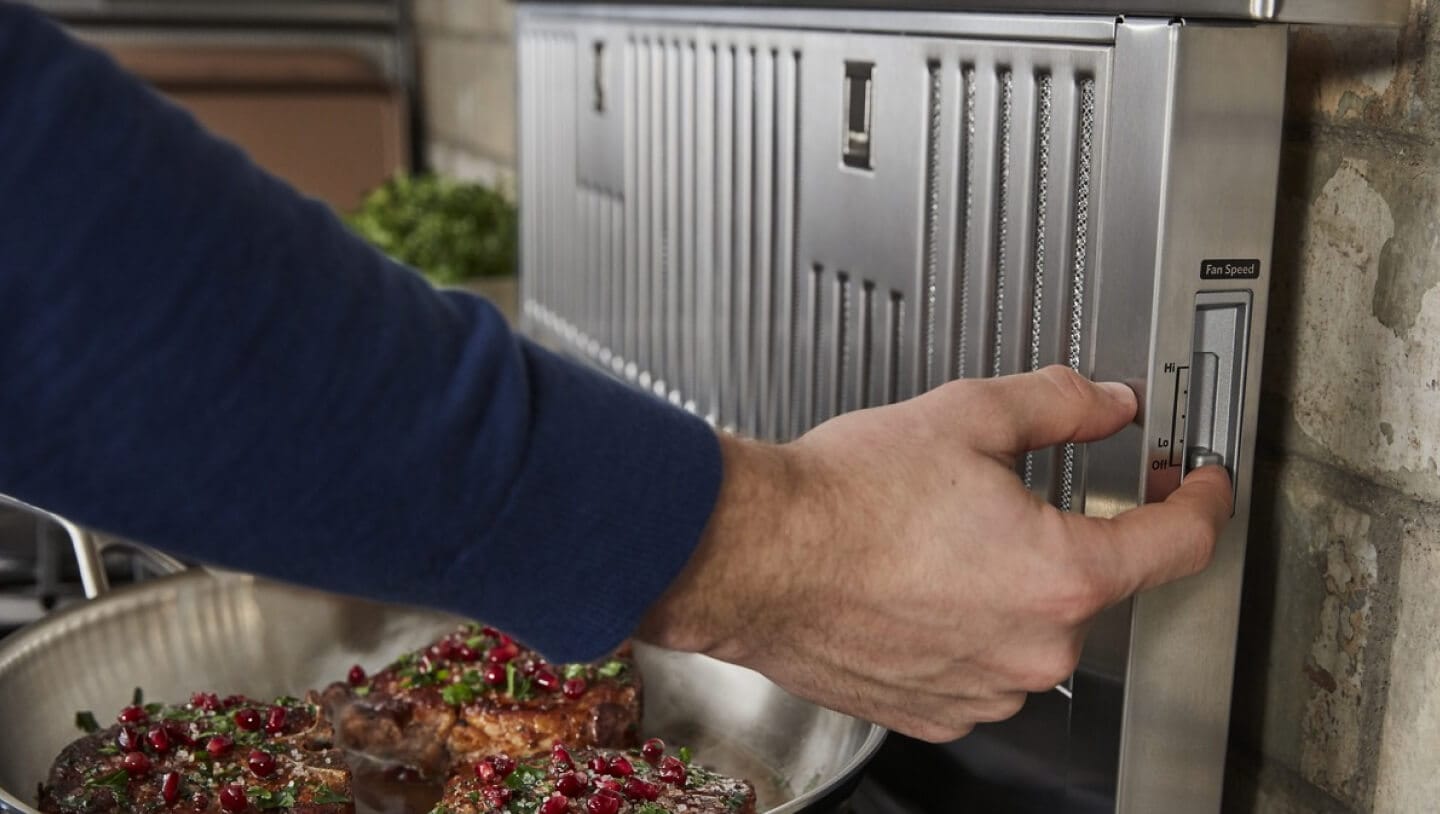 Person turning on a downdraft vent hood