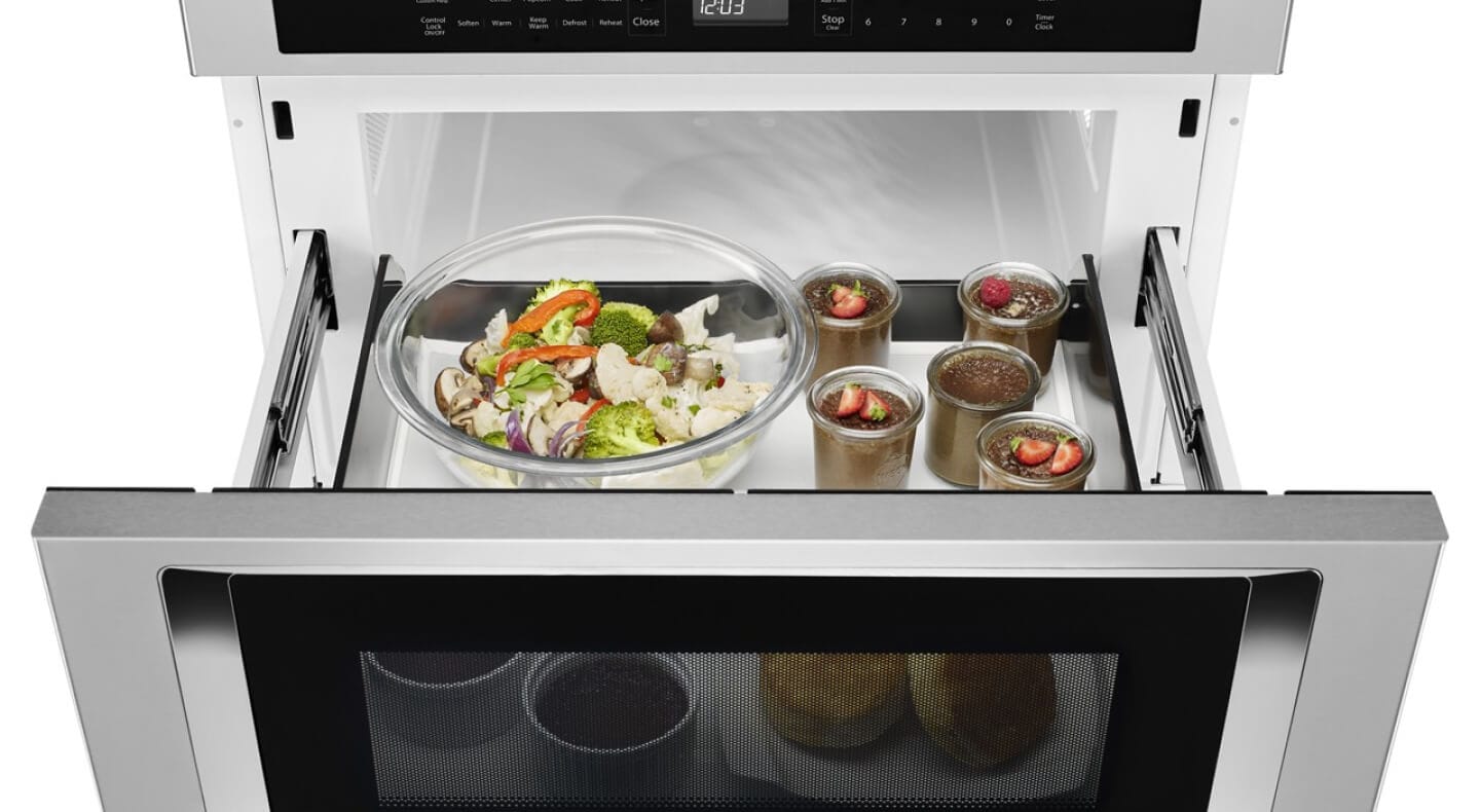 An open KitchenAid® undercounter microwave oven drawer with an assortment of food inside An open KitchenAid® undercounter microwave oven drawer with an assortment of food inside