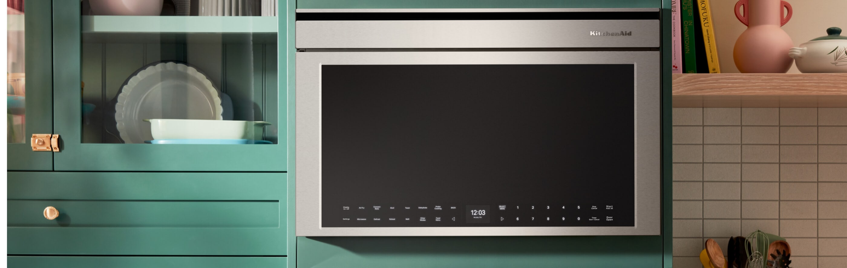 Stainless steel KitchenAid® over-the-range microwave in bright blue cabinetry