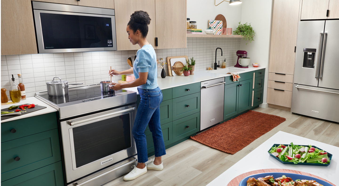 Person stirring food in a saucepan on an electric stovetop