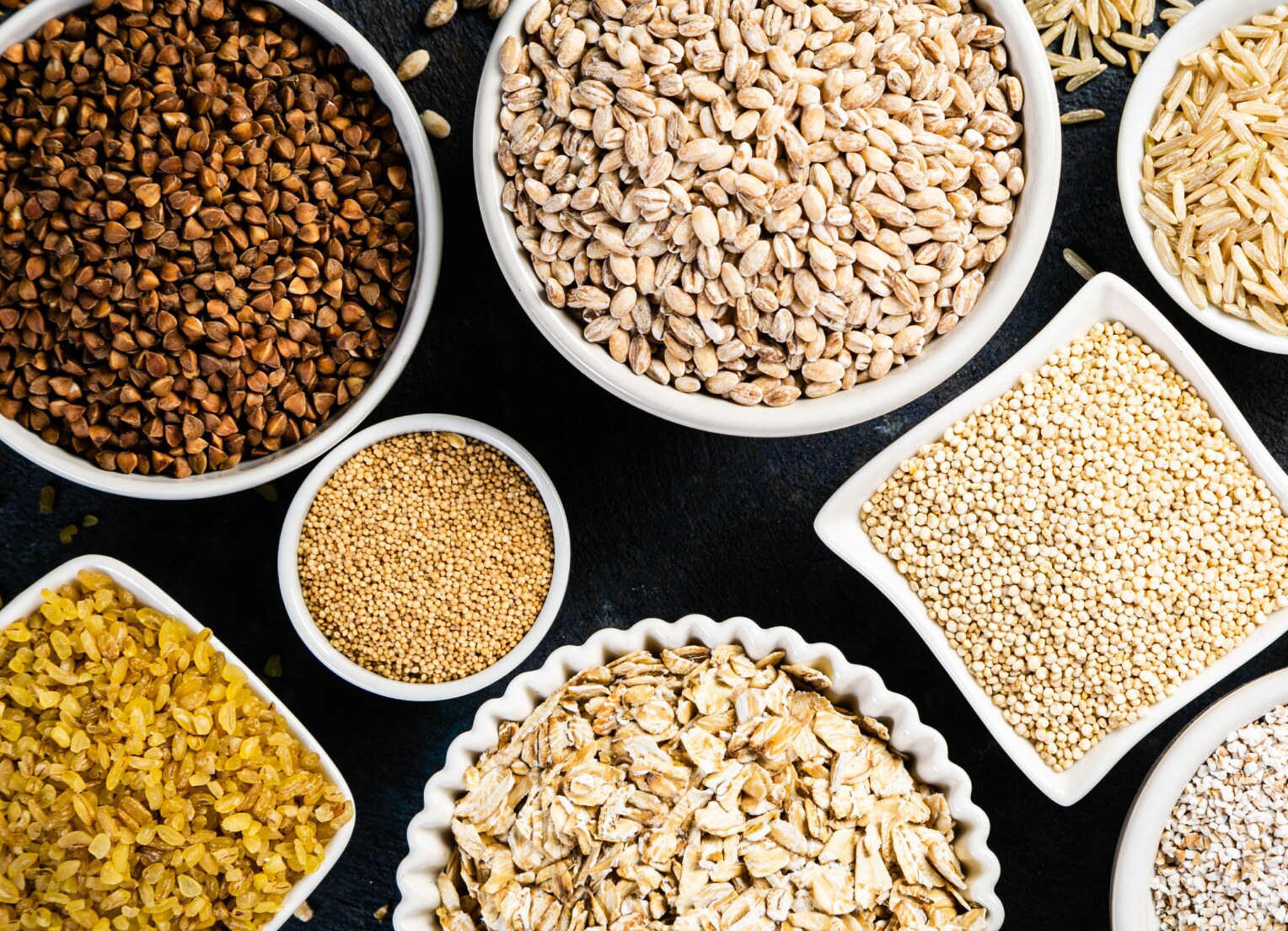 Several bowls filled with beans and grains