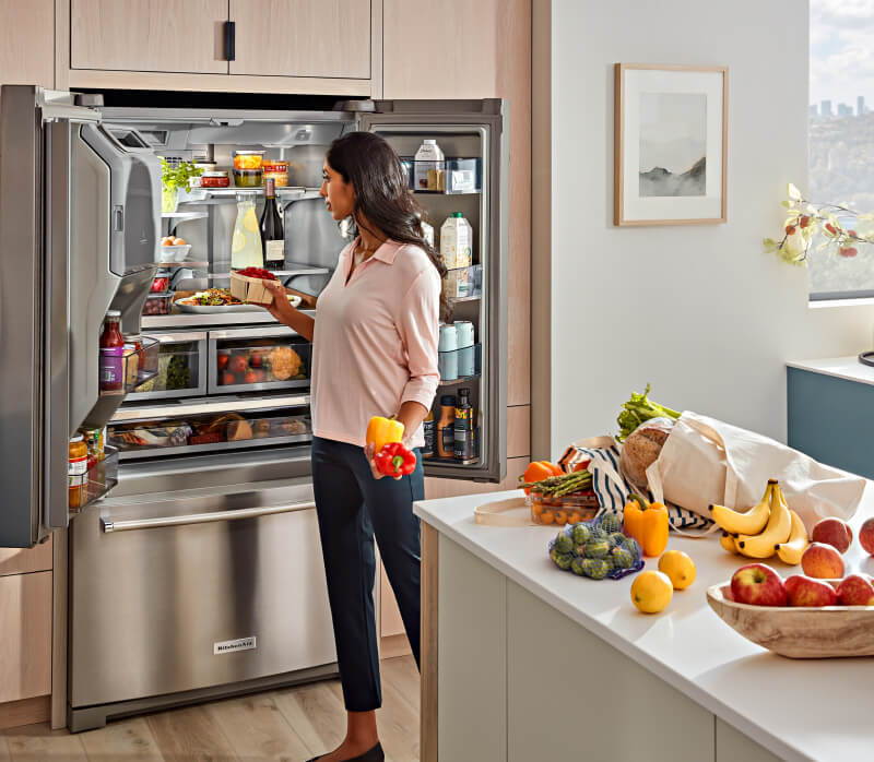 KitchenAid® French Door Bottom Mount Refrigerator actively being loaded.