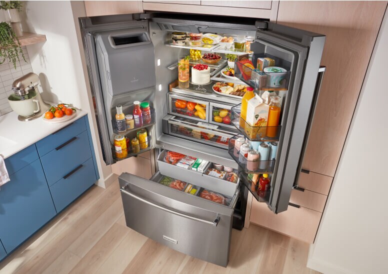 A fully loaded KitchenAid® French Door Bottom Mount Refrigerator with the doors and drawers open.