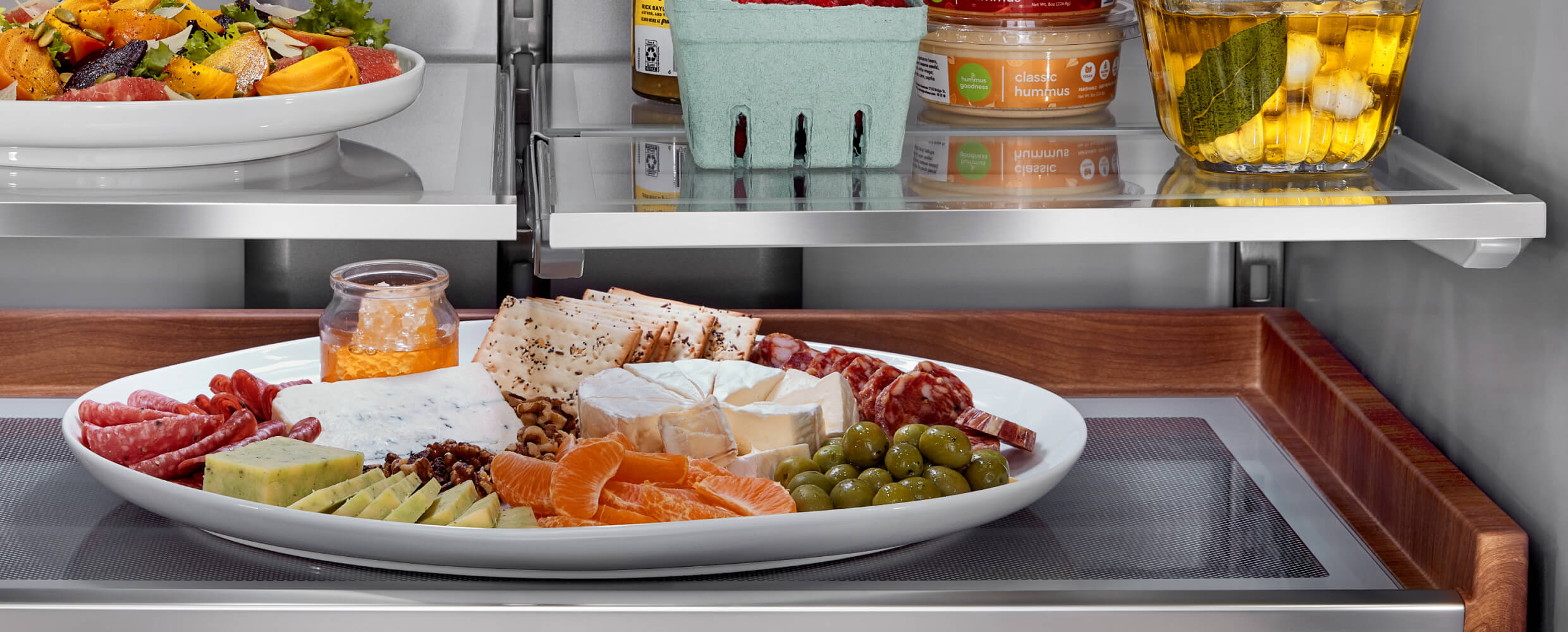 A charcuterie board on the Premium Wood-Look Finish Sliding Storage Tray.