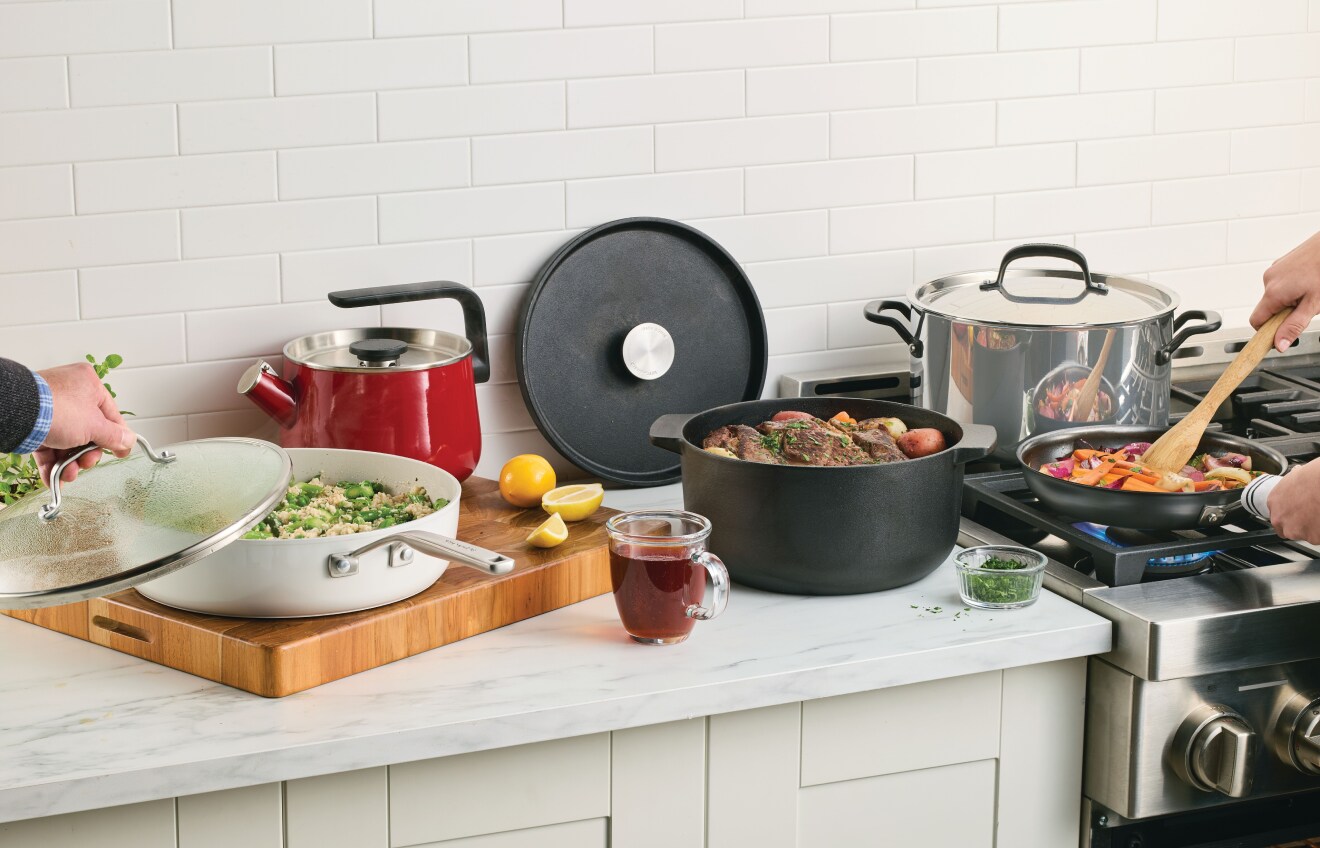 People preparing a meal in a with KitchenAid® Cookware and Kettles