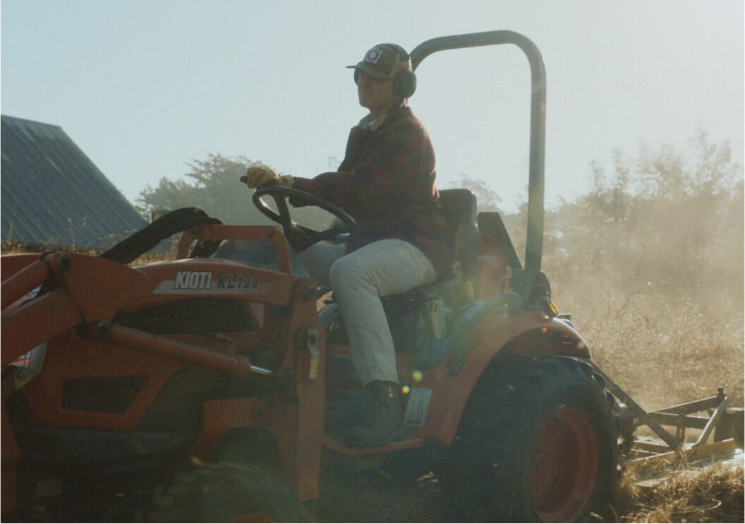 A man driving a small tractor.