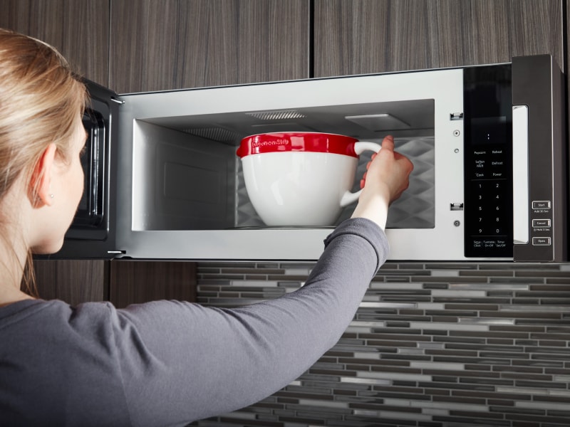 Person placing a bowl in the microwave