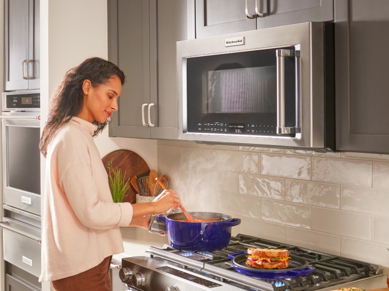 Person cooking on a KitchenAid® gas cooktop Person cooking on a KitchenAid® gas cooktop
