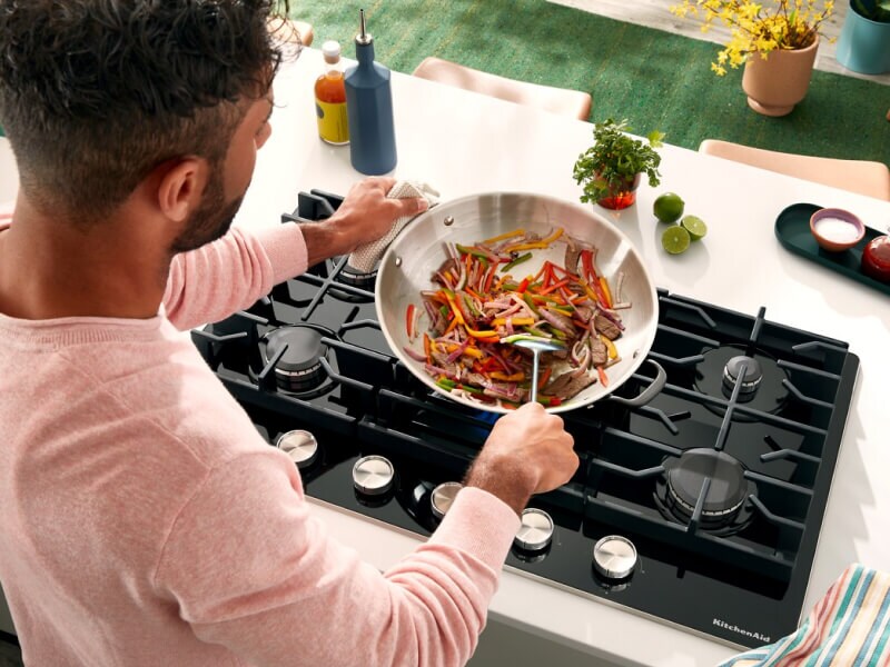 Person cooking on a gas cooktop