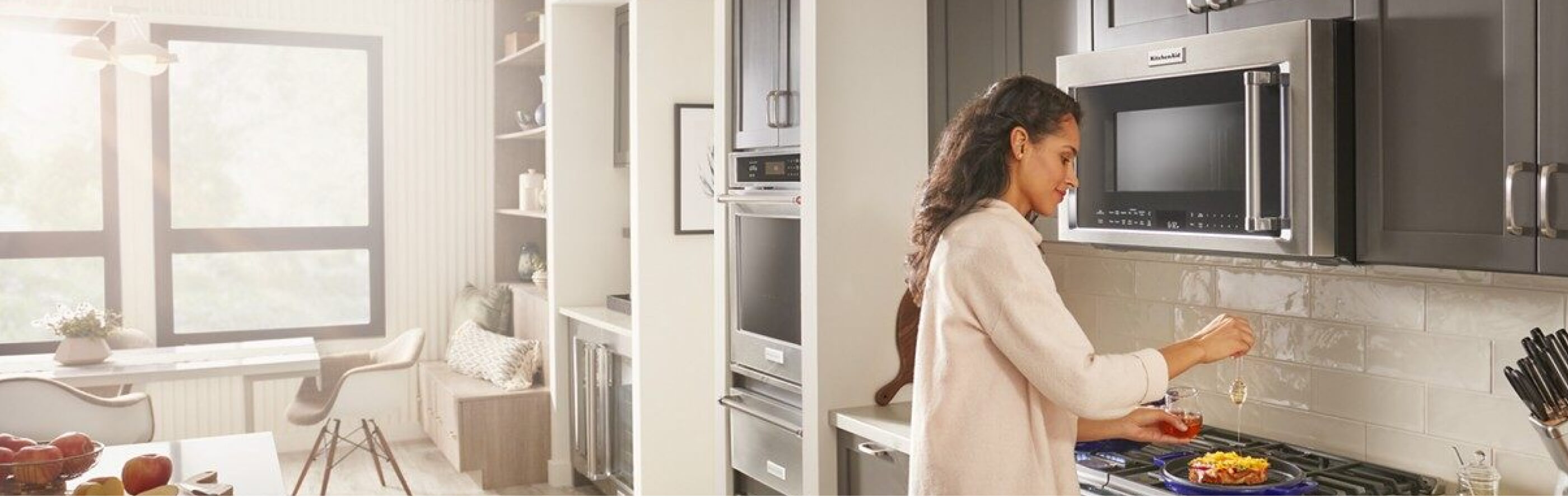 Person cooking on a stovetop with a KitchenAid® over-the-range microwave above