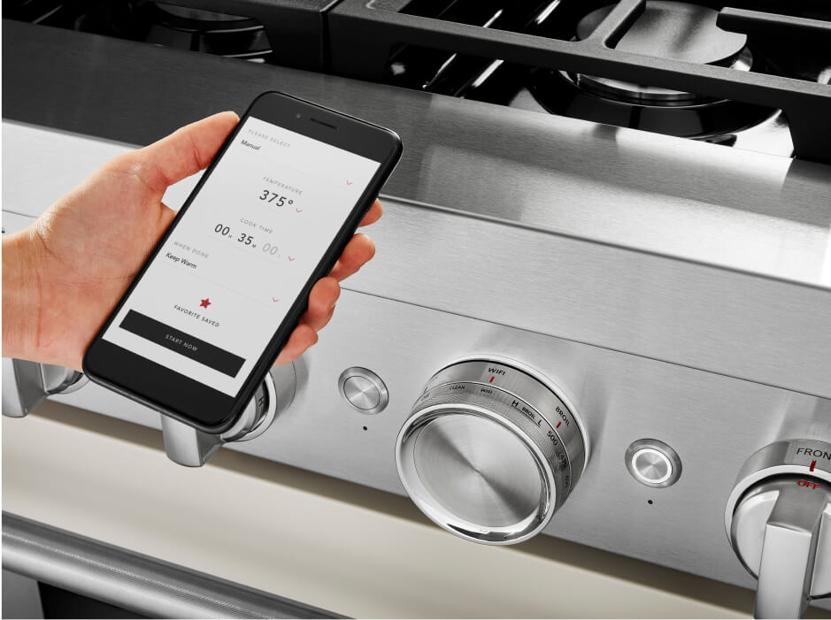 A person using the KitchenAid® app on their smartphone to monitor the connected appliance. A person using the KitchenAid® app on their smartphone to monitor the connected appliance.