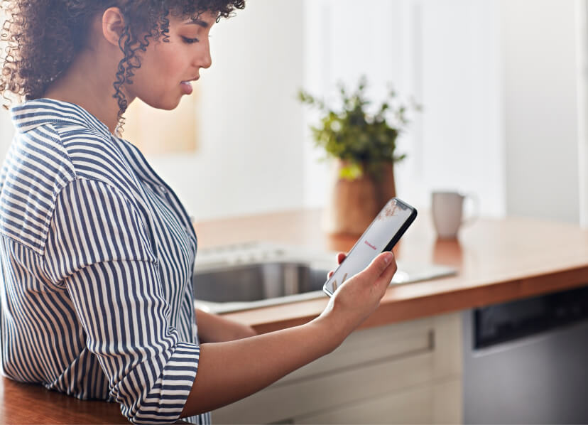 A woman familiarizing herself with her new KitchenAid® app. A woman familiarizing herself with her new KitchenAid® app.