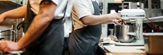 A KitchenAid® professional stand mixer being used in a restaurant kitchen. A KitchenAid® professional stand mixer being used in a restaurant kitchen.