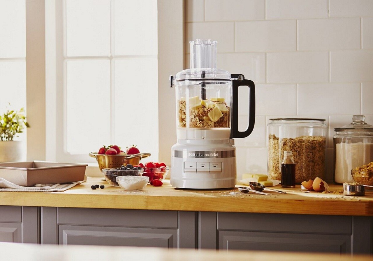A KitchenAid® food processor filled with butter and oats