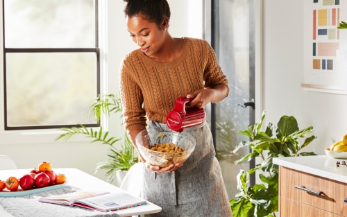 Woman making dough with a KitchenAid® cordless hand mixer