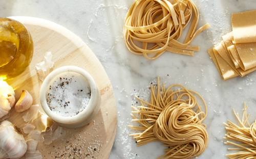 Homemade pasta nests and ingredients on a kitchen counter.