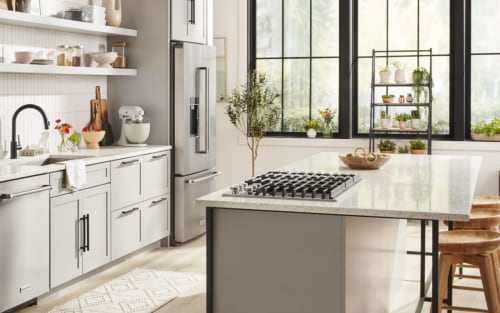 White kitchen with large island and KitchenAid® appliances.