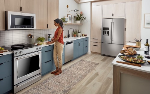 Kitchen with a KitchenAid® French door refrigerator built into light brown cabinetry