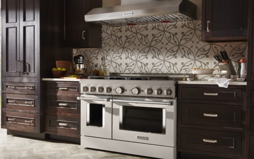 A commercial-style range surrounded by dark cabinetry