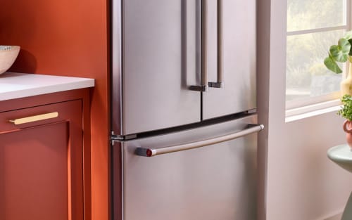 A KitchenAid® French door refrigerator next to terracotta cabinets