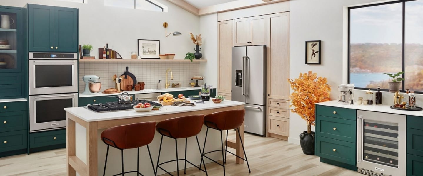 Kitchen with double oven, refrigerator and island with cooktop