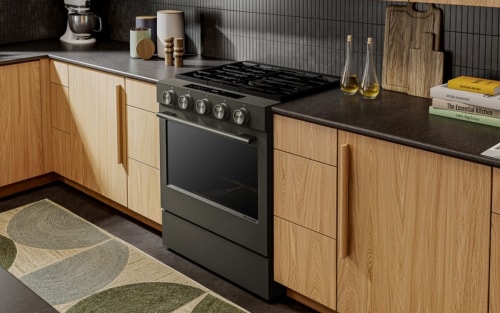 A kitchen with a warm feel, gas stove, and dark countertops