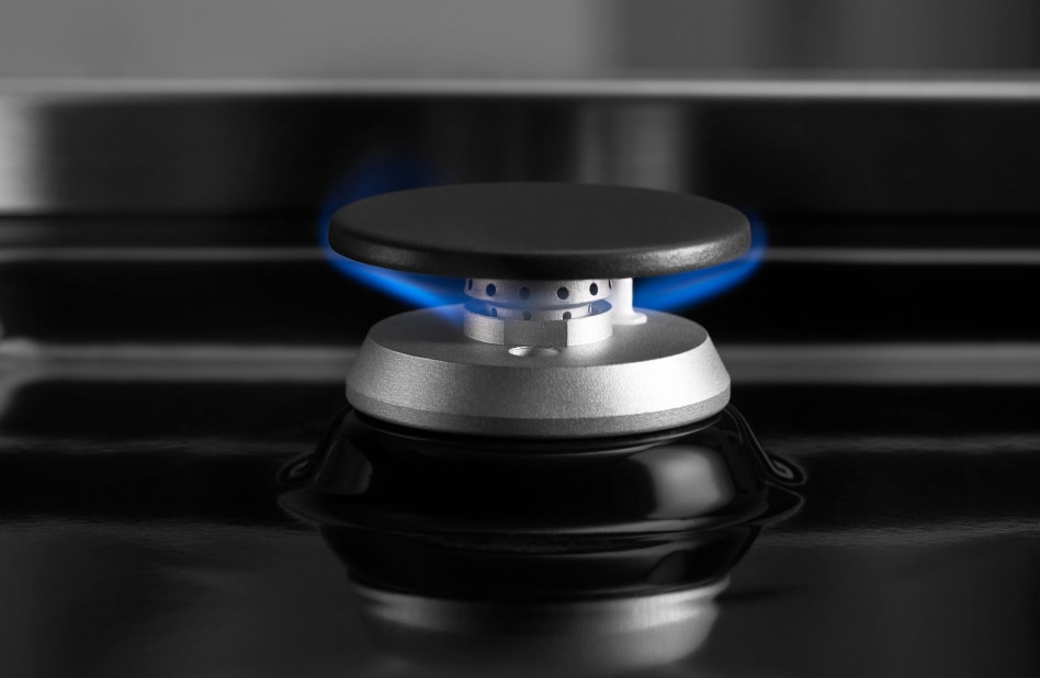 Gas burner ignited and flickering under a grate. Gas burner ignited and flickering under a grate.
