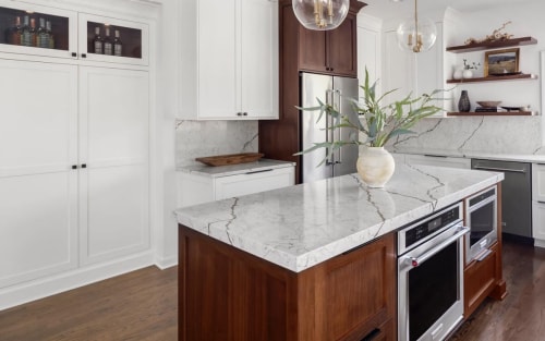 A bright kitchen with a white, marble-like island