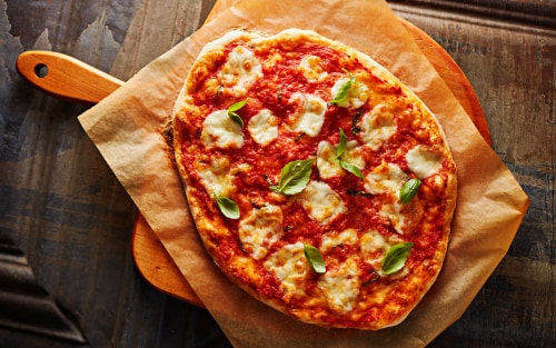 A pizza on a wooden cutting board