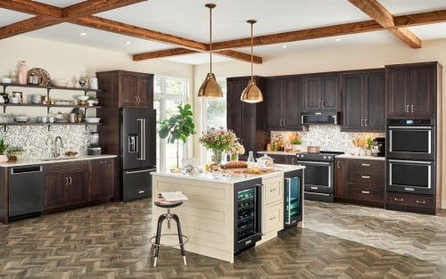 A large kitchen with an island and dark appliances
