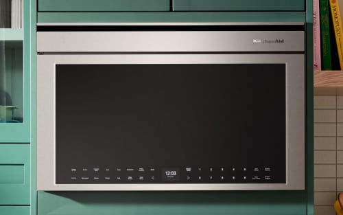 Stainless steel KitchenAid® over-the-range microwave in bright blue cabinetry