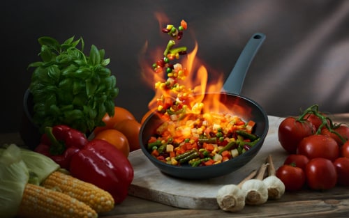 Skillet with food being flambéed