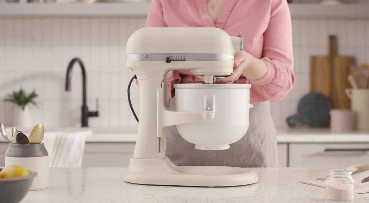 Person using white KitchenAid® stand mixer on white counter